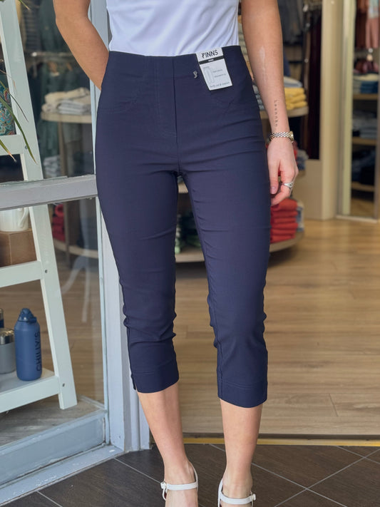 Person wearing navy blue pants with a store interior in the background