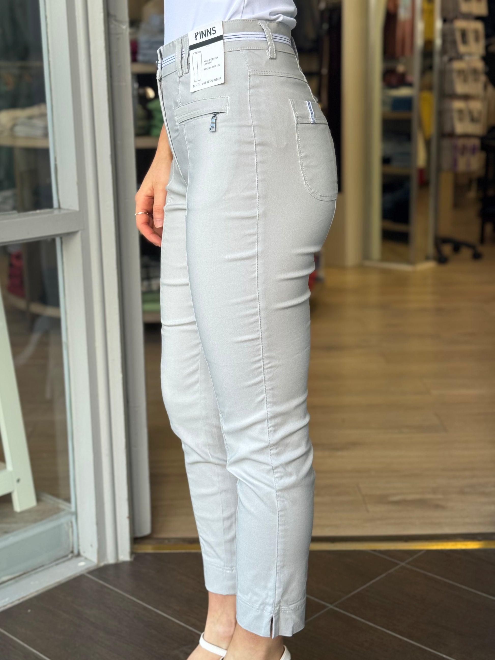 Person wearing light gray pants with a store interior background