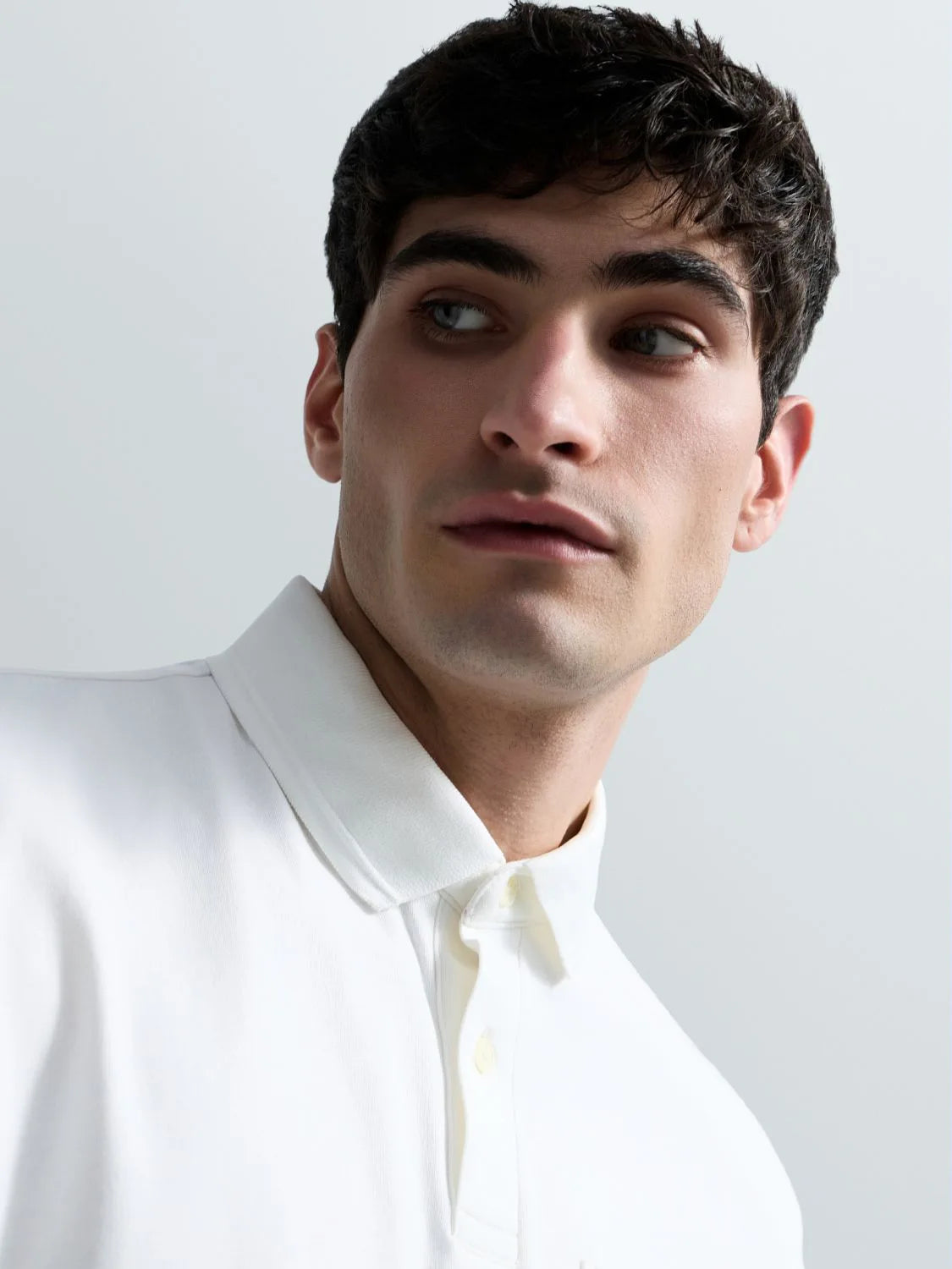 Man wearing a white shirt against a light gray background