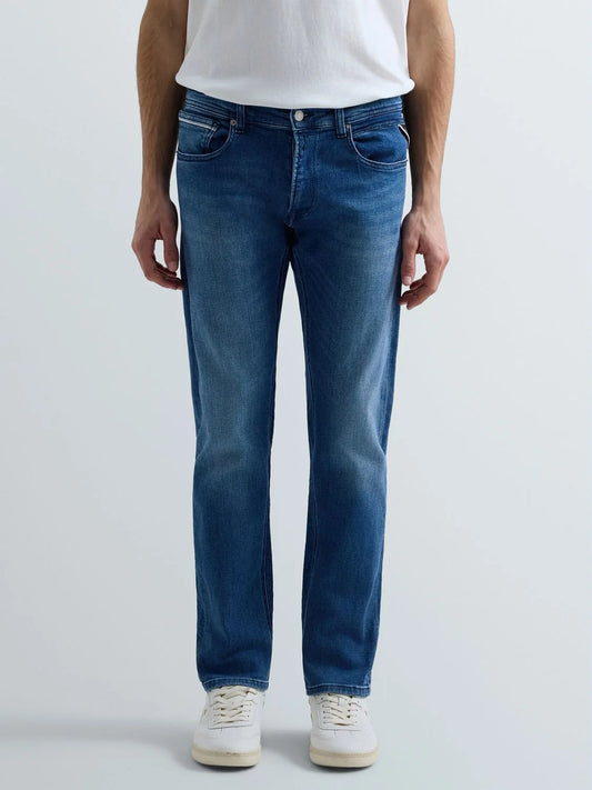 Person wearing blue jeans and a white shirt on a light gray background