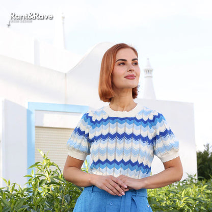 Woman wearing a blue and white patterned top with a blurred background