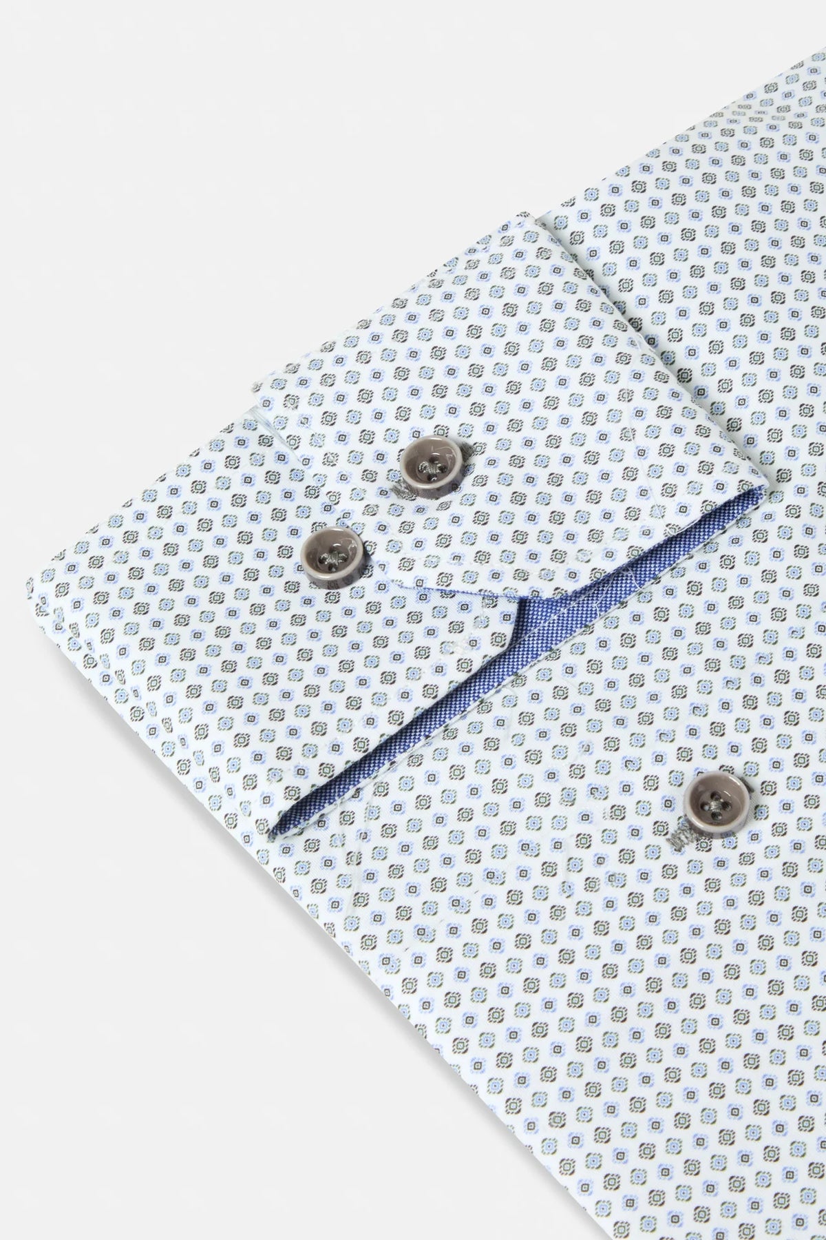 Close-up of a light blue and white patterned dress shirt cuff with brown buttons and a blue inner lining.