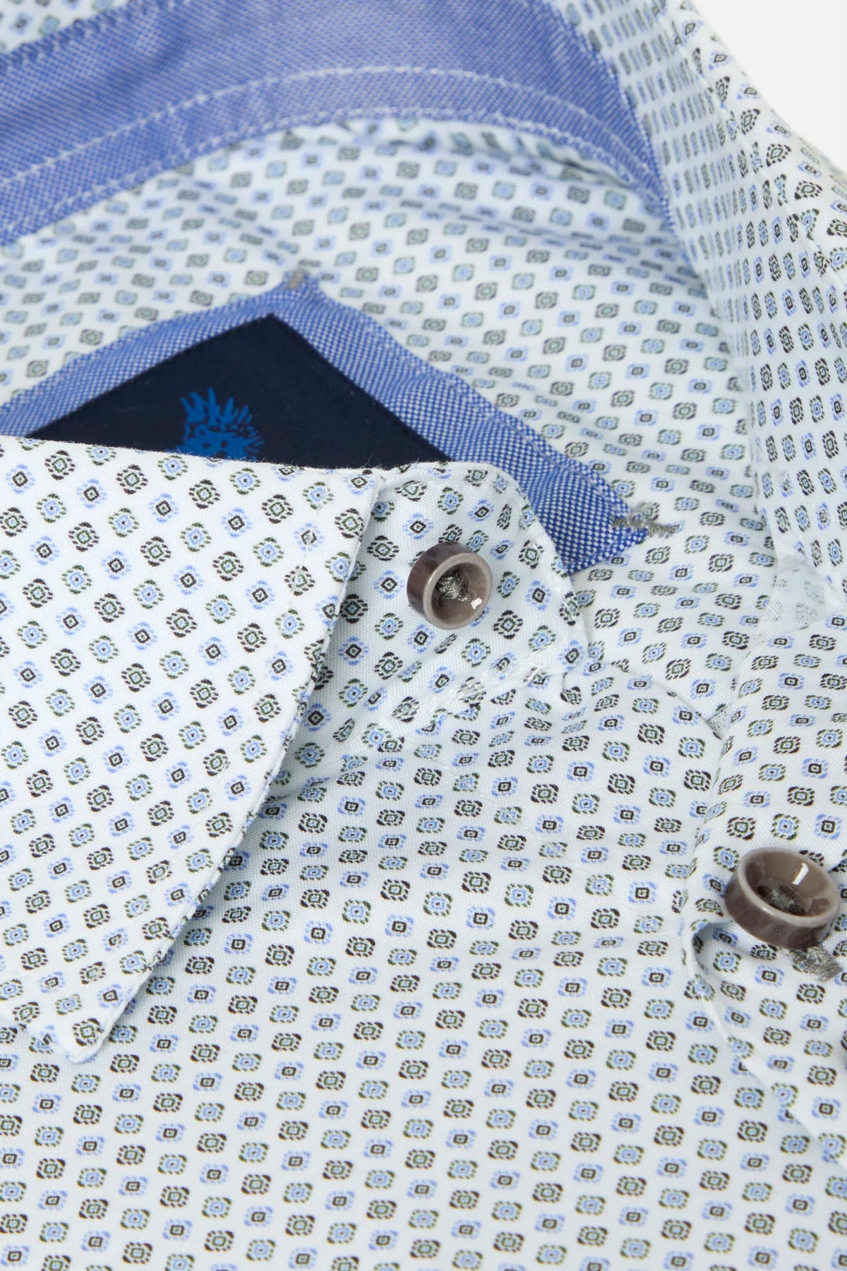 Close-up of a patterned button-down shirt collar with a light blue and white micro-check design, brown buttons, and a blue inner neck lining.