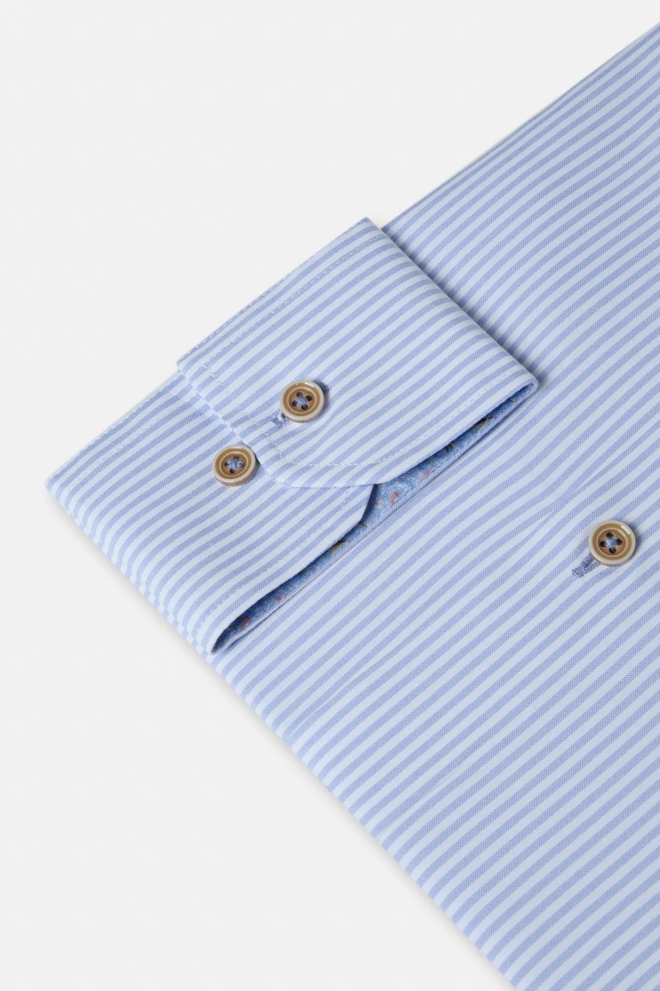 Close-up of a light blue striped shirt with rolled-up sleeves on a white background