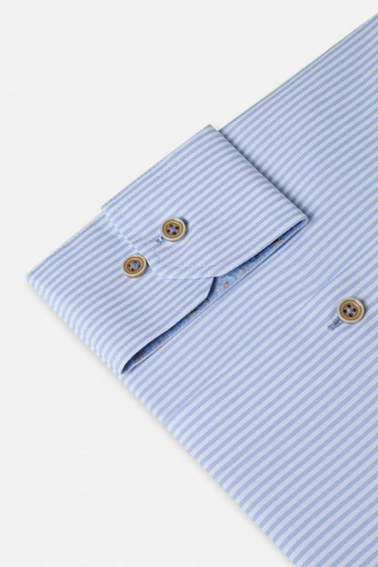 Close-up of a light blue striped shirt with rolled-up sleeves on a white background
