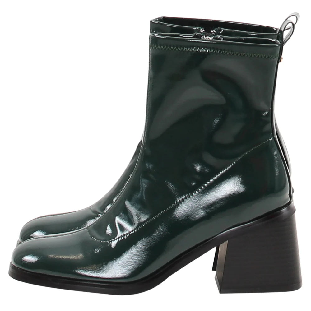 Green patent leather boots on a white background