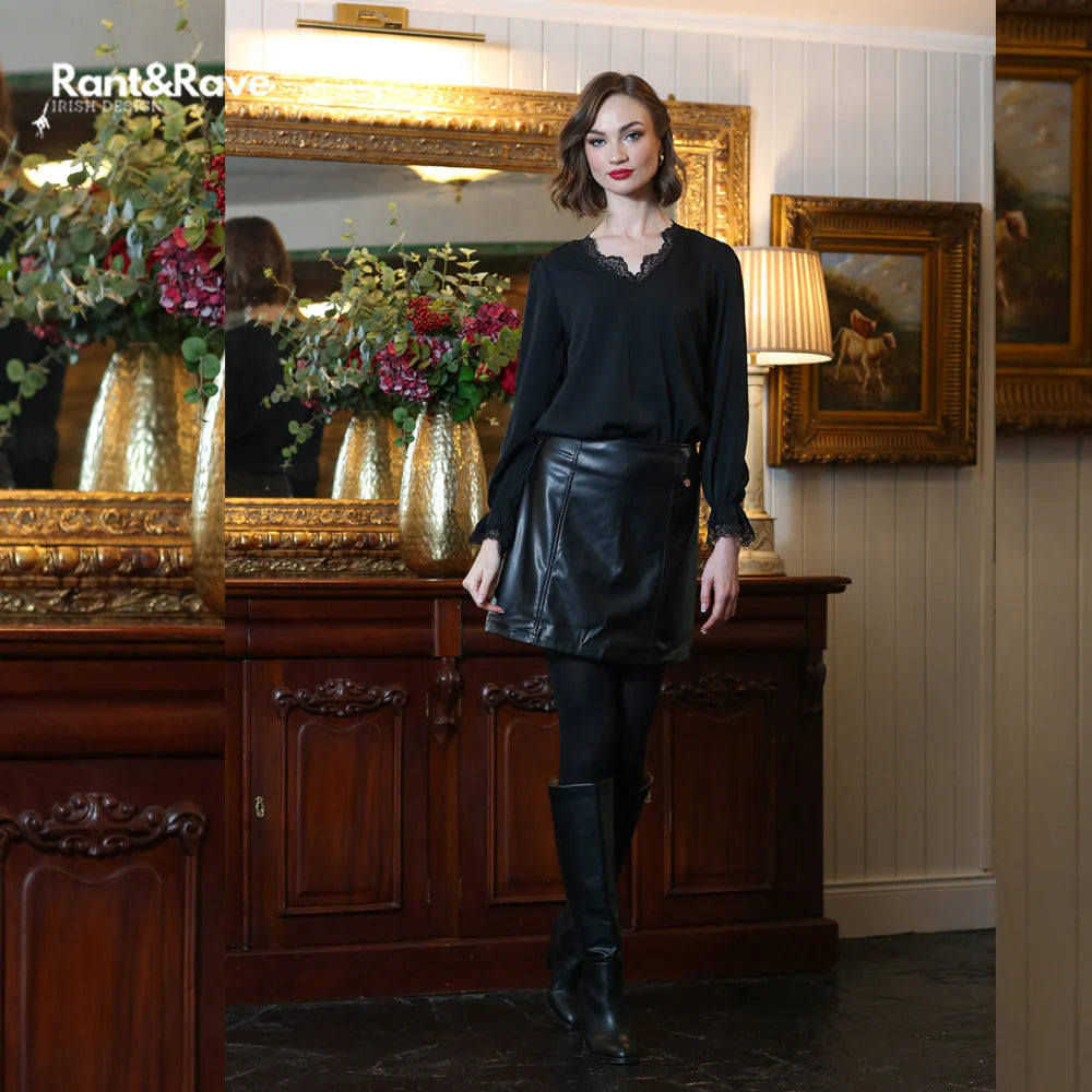Woman in black outfit standing in a room with decorative elements and 'Rant&Raw' branding.