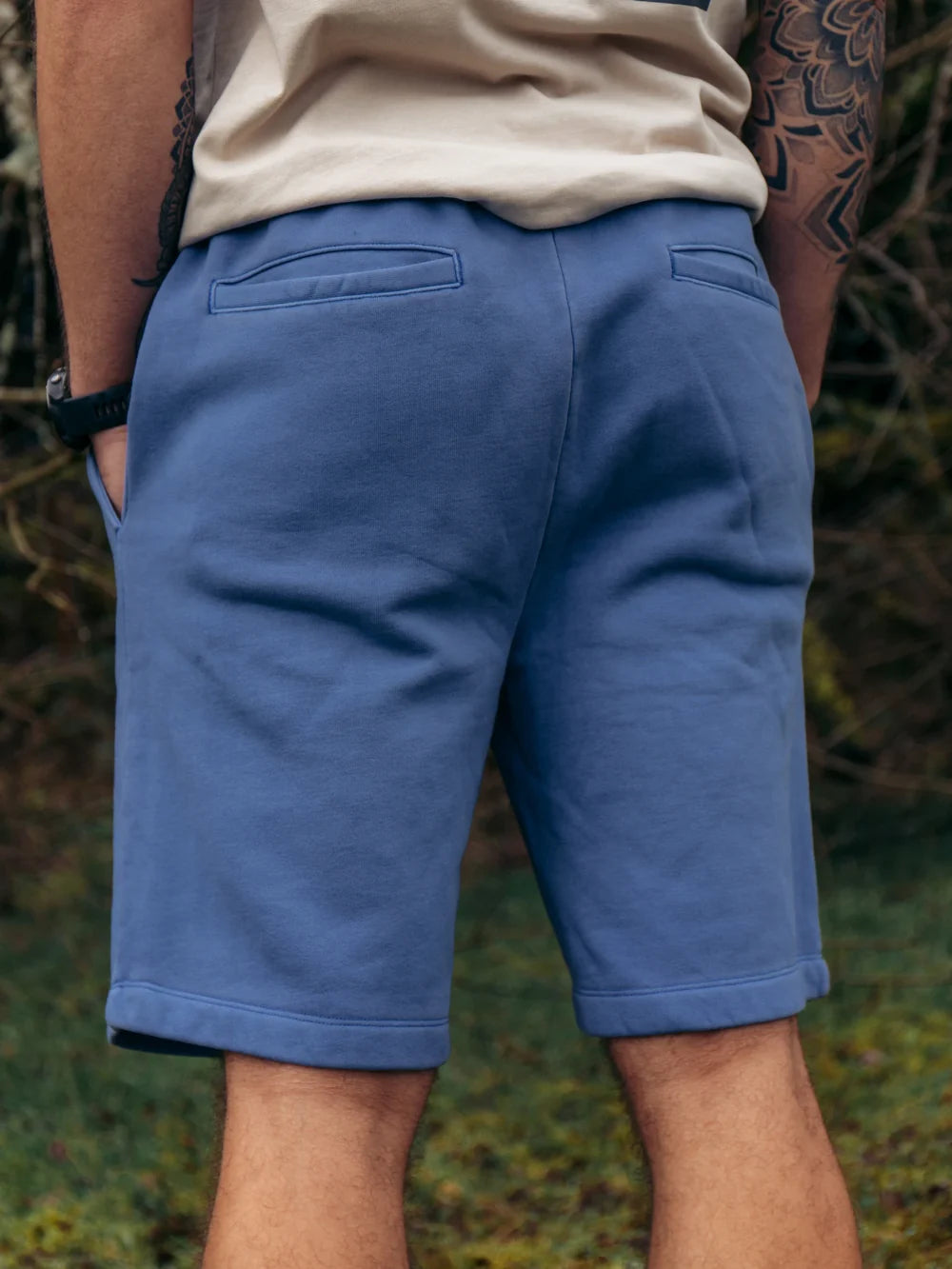Person wearing blue shorts with a natural background