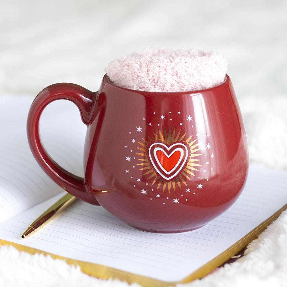 Red mug with heart design on a white surface