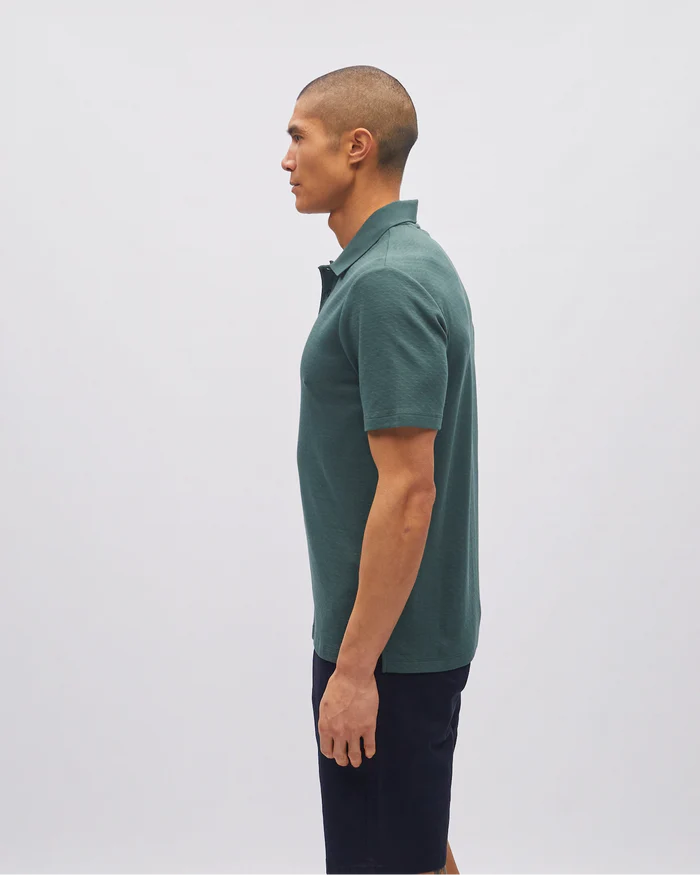 Man wearing a green polo shirt against a white background
