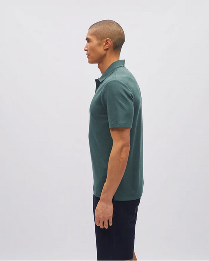 Man wearing a green polo shirt against a white background