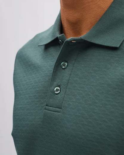 Green polo shirt on a plain background