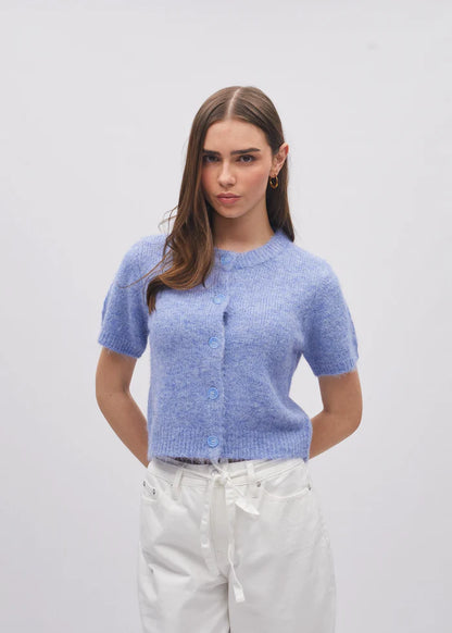 Woman wearing a light blue knitted cardigan against a plain background