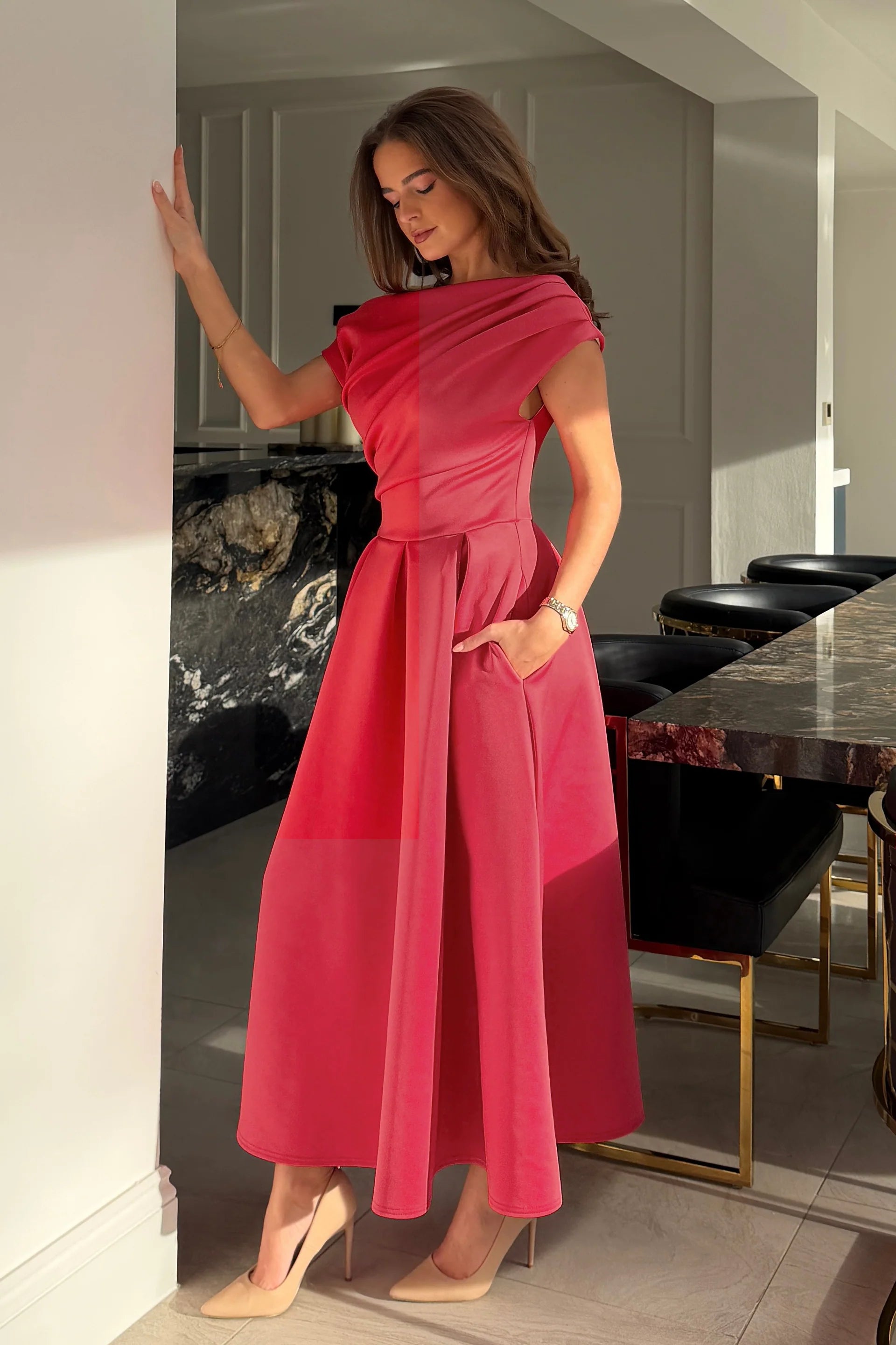 Woman in a pink dress standing in a modern interior setting