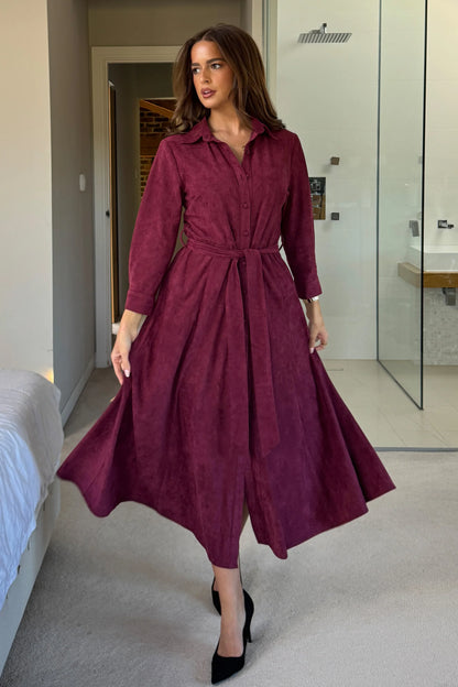 Woman wearing a burgundy dress in a modern interior setting