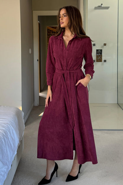 Woman wearing a burgundy dress in a bedroom setting