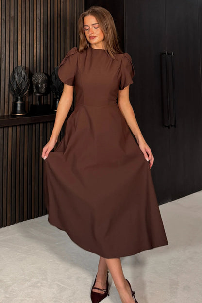 Woman wearing a brown dress in an indoor setting