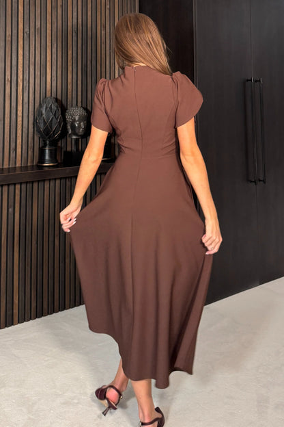 Woman wearing a brown dress in an indoor setting