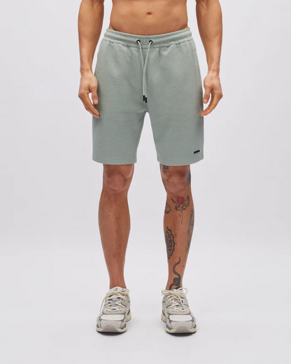 Person wearing light gray shorts on a white background
