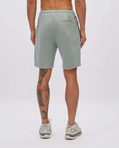 Person wearing light gray shorts on a white background