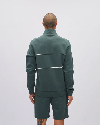 Person wearing a green tracksuit with white stripes on a light gray background