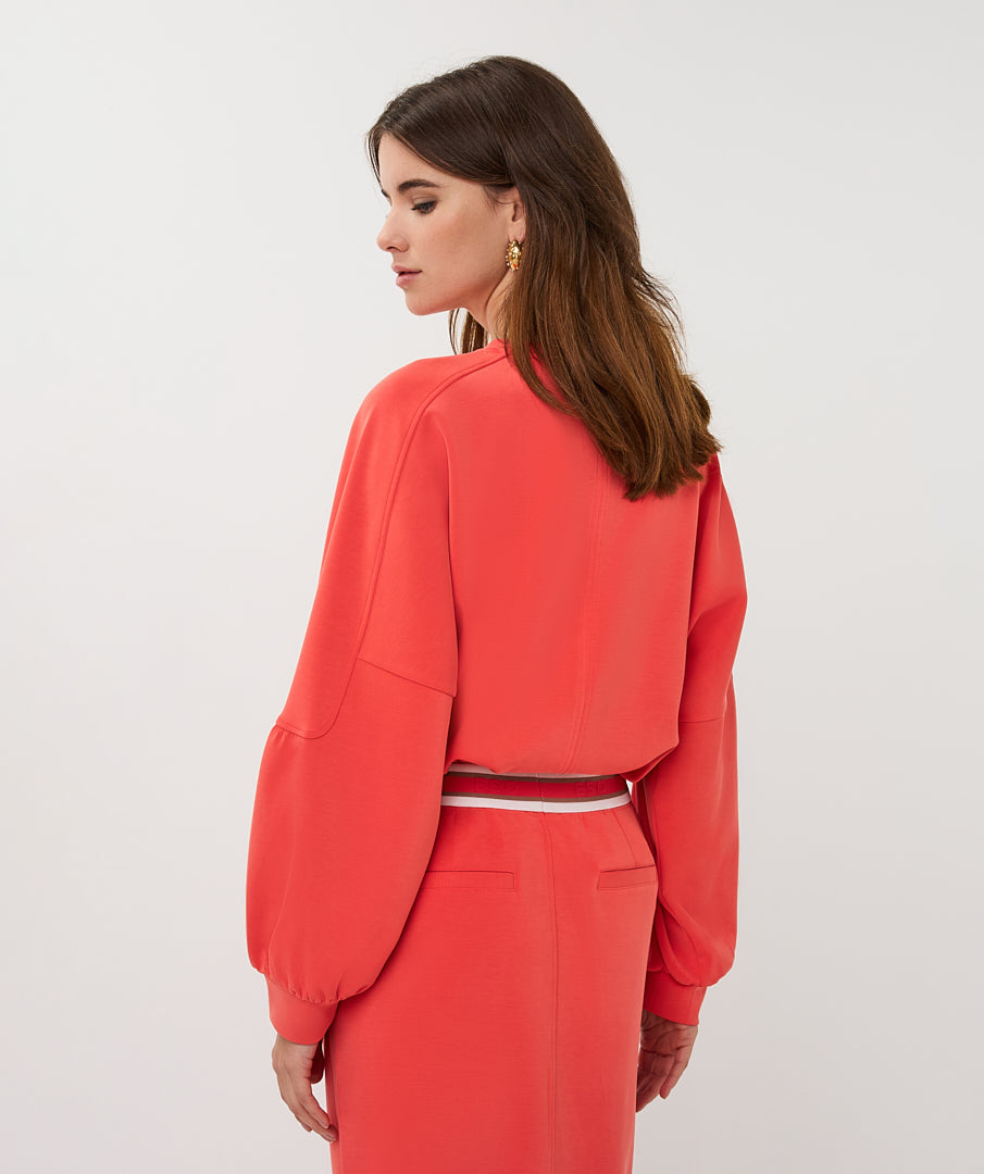 Woman wearing a coral Two piece on a white background
