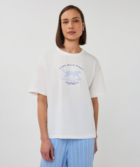 Person wearing a white t-shirt with a graphic design on a plain background