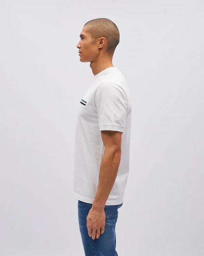 Man wearing a white t-shirt with a small logo on a plain background