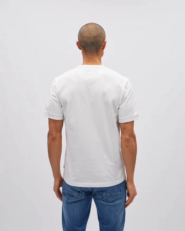 Man wearing a plain white t-shirt and blue jeans on a light gray background