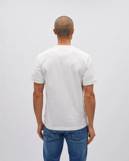 Man wearing a plain white t-shirt and blue jeans on a light gray background