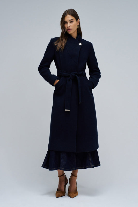 Woman wearing a navy blue coat on a white background