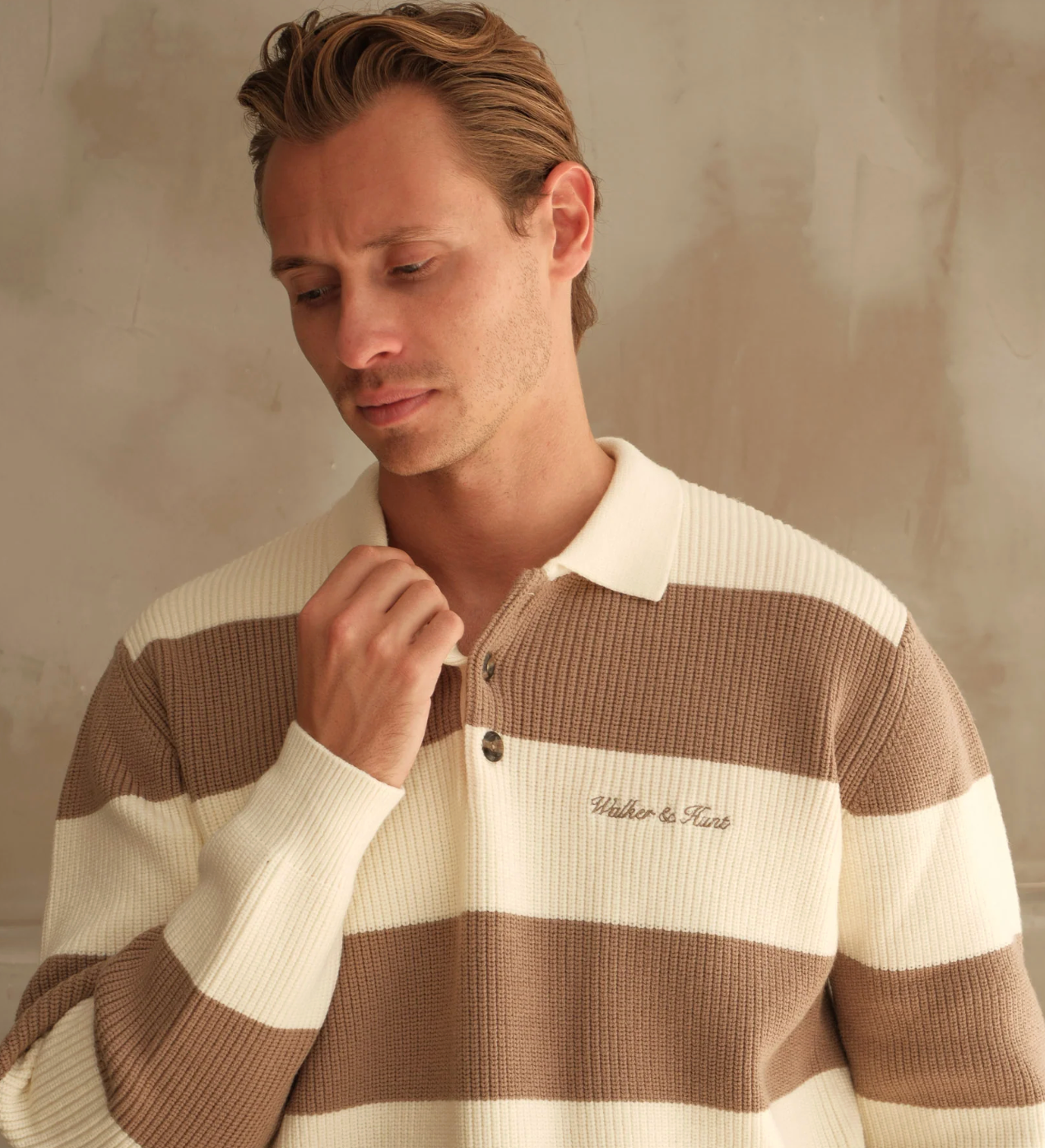 Man wearing a brown and beige striped sweater with 'Viktor & Rolf' branding.