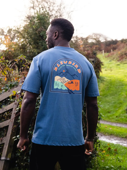 Man wearing a blue t-shirt with a graphic design outdoors