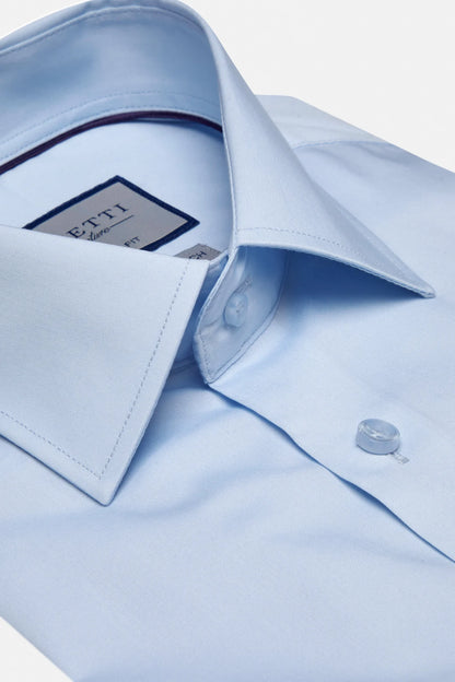 Close-up of a light blue dress shirt with a collar and cuff, featuring a brand label.