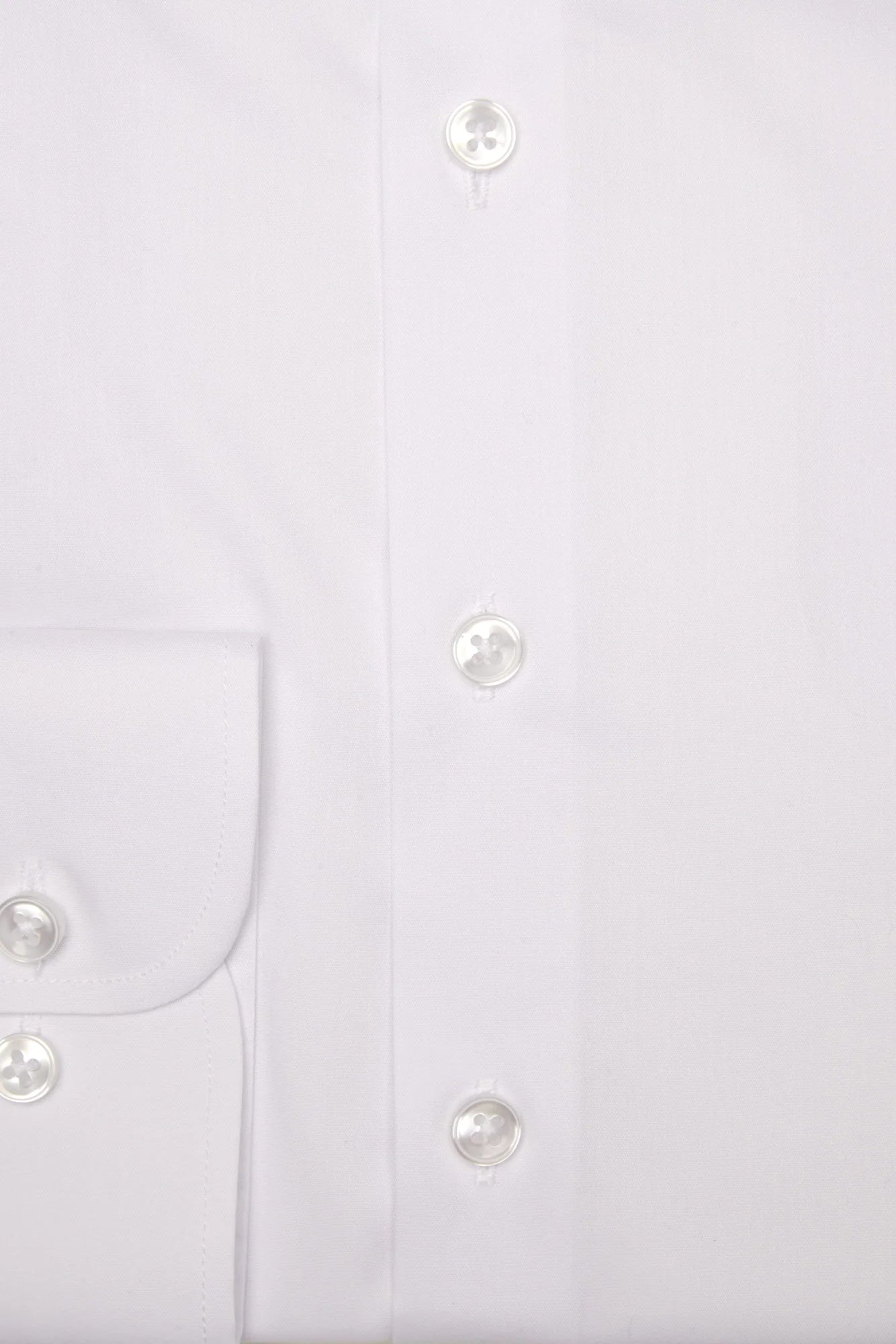 Close-up of a white shirt with buttons on a light gray background