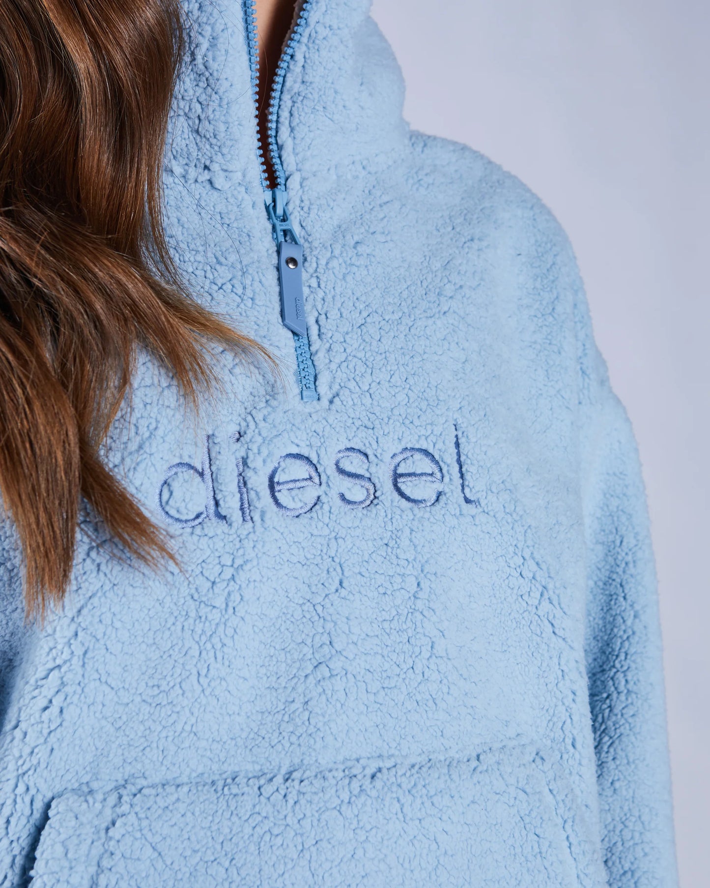 Light blue fleece pullover with 'Diesel' branding on a plain background