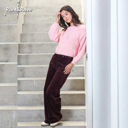 Woman in pink sweater and brown pants standing on a staircase, with 'Rant&Rave' branding.
