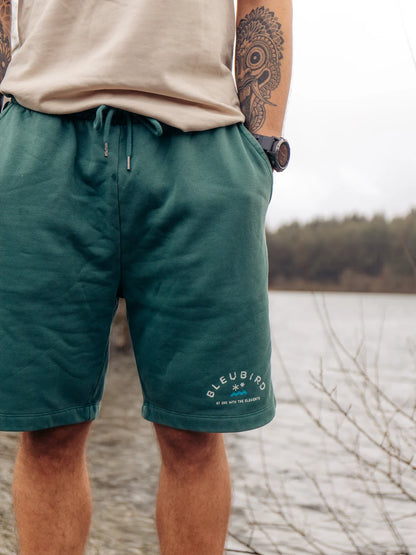Person wearing green shorts with a blurred natural background