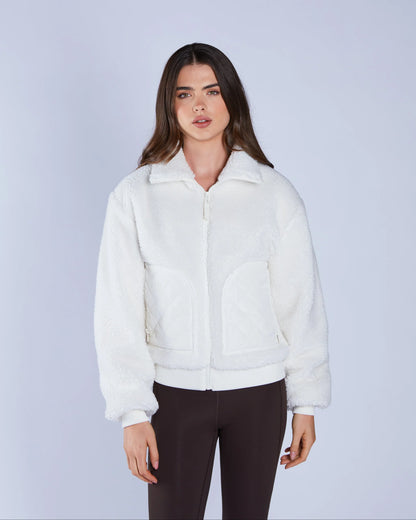 Woman wearing a white jacket against a light gray background