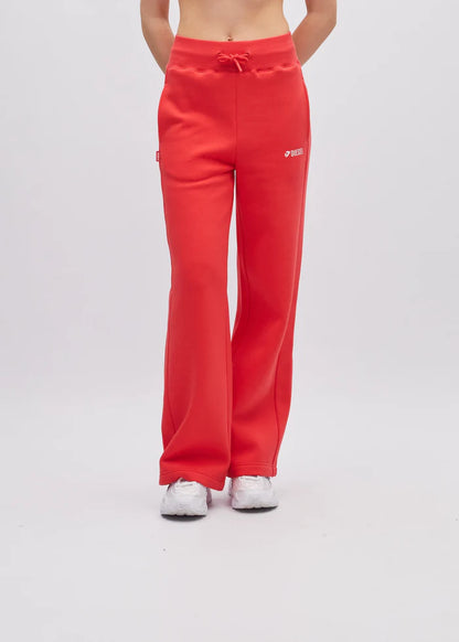 Red sweatpants worn by a person on a white background