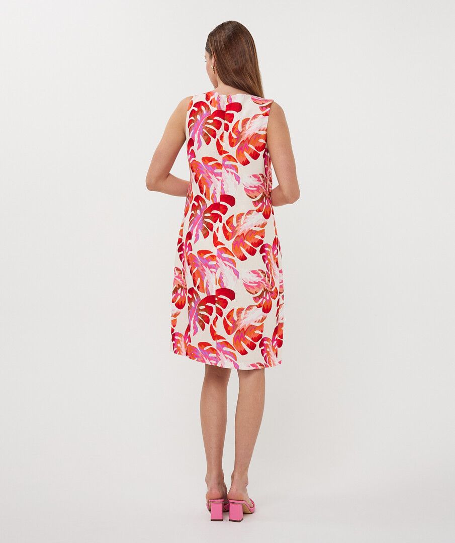 Woman wearing a sleeveless dress with a floral pattern on a white background