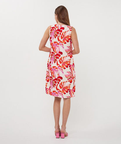 Woman wearing a sleeveless dress with a floral pattern on a white background