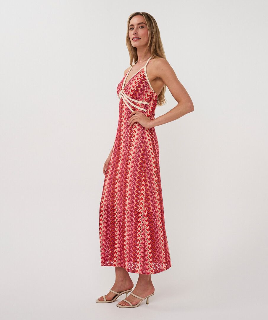 Woman wearing a red patterned dress on a white background