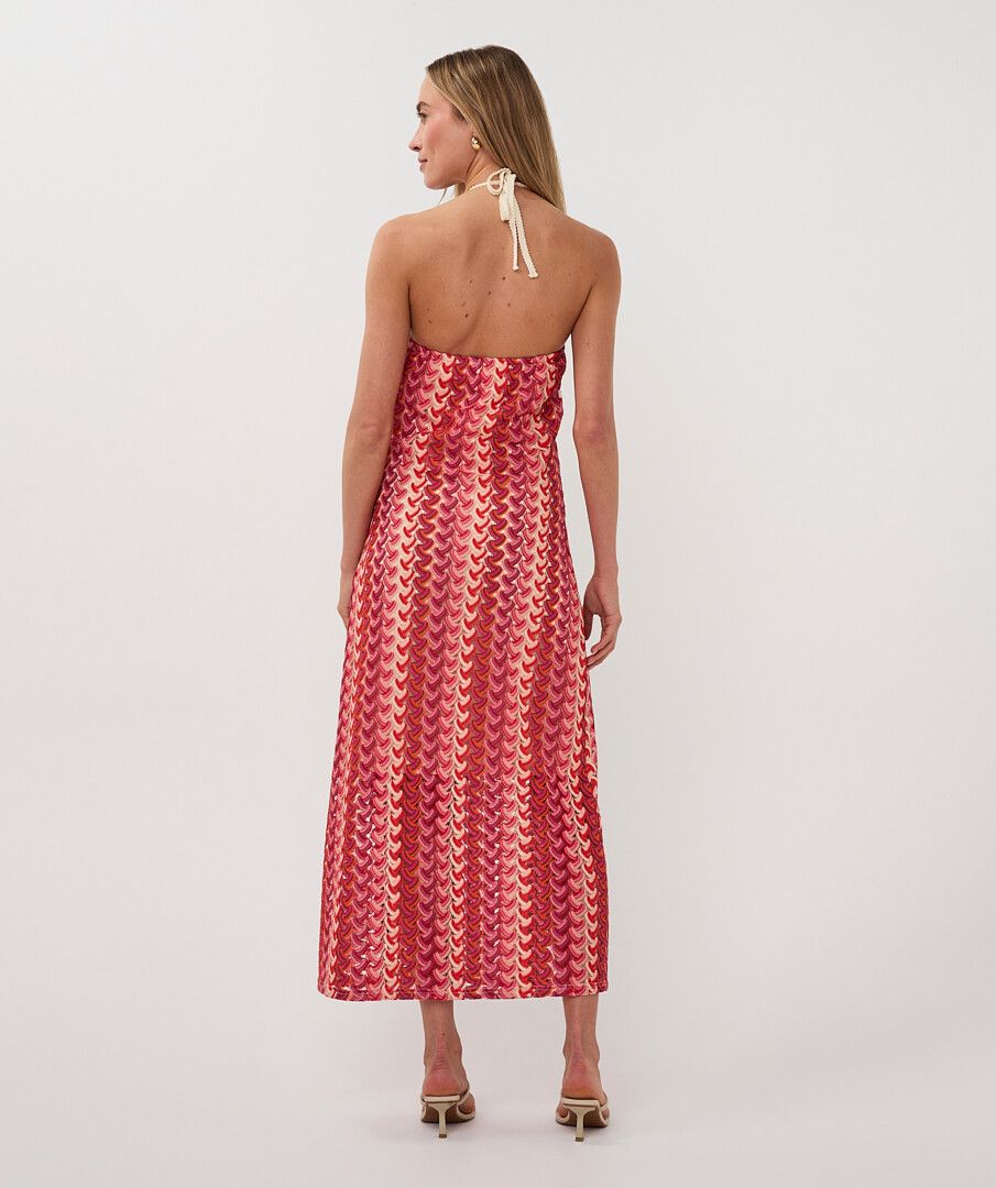 Woman wearing a red patterned strapless dress on a white background