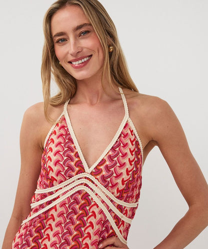 Woman wearing a red and white patterned dress on a plain background