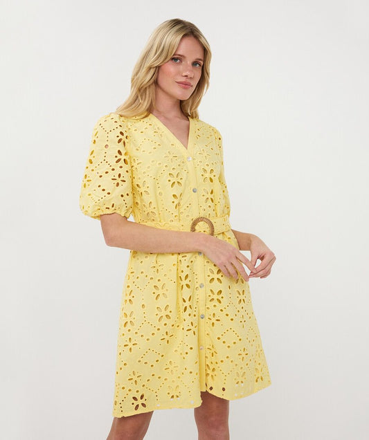 Woman wearing a yellow dress with floral cut-out details on a white background