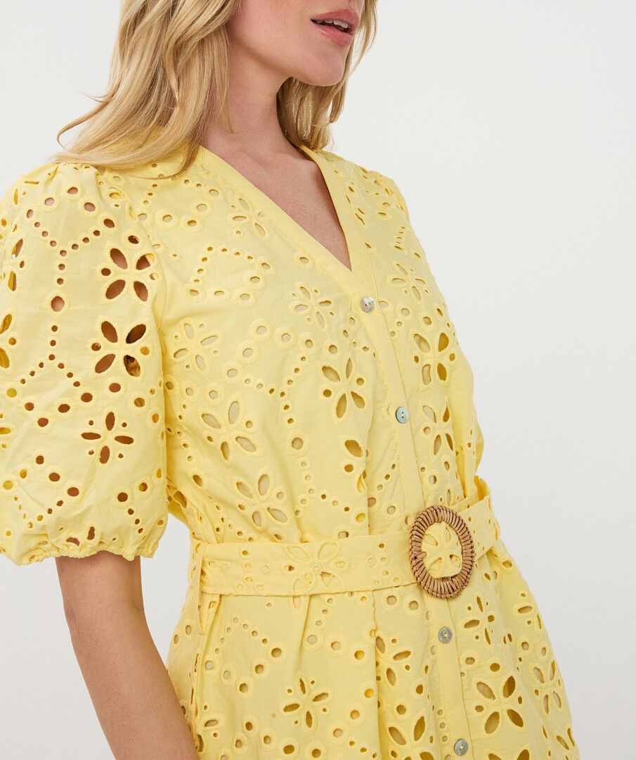 Yellow dress with floral cut-out pattern on a white background