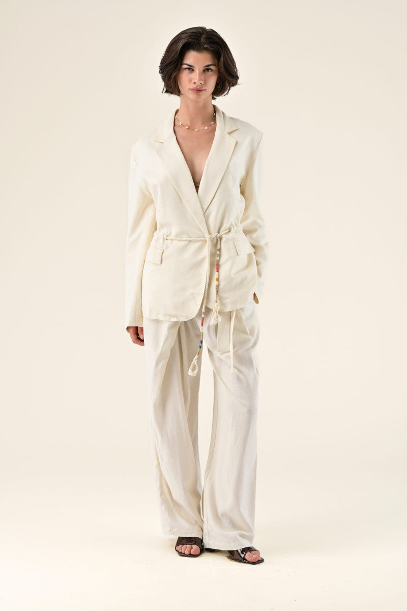 Woman wearing a cream-colored suit on a white background