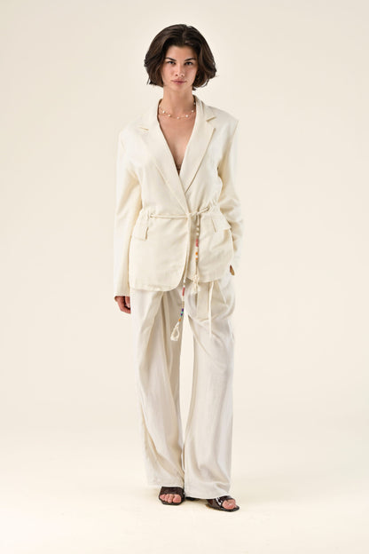 Woman wearing a cream-colored suit on a white background