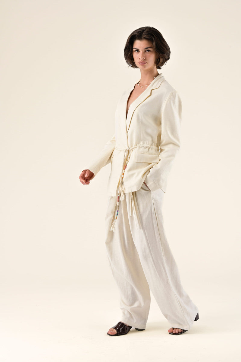 Woman wearing a cream-colored outfit on a white background